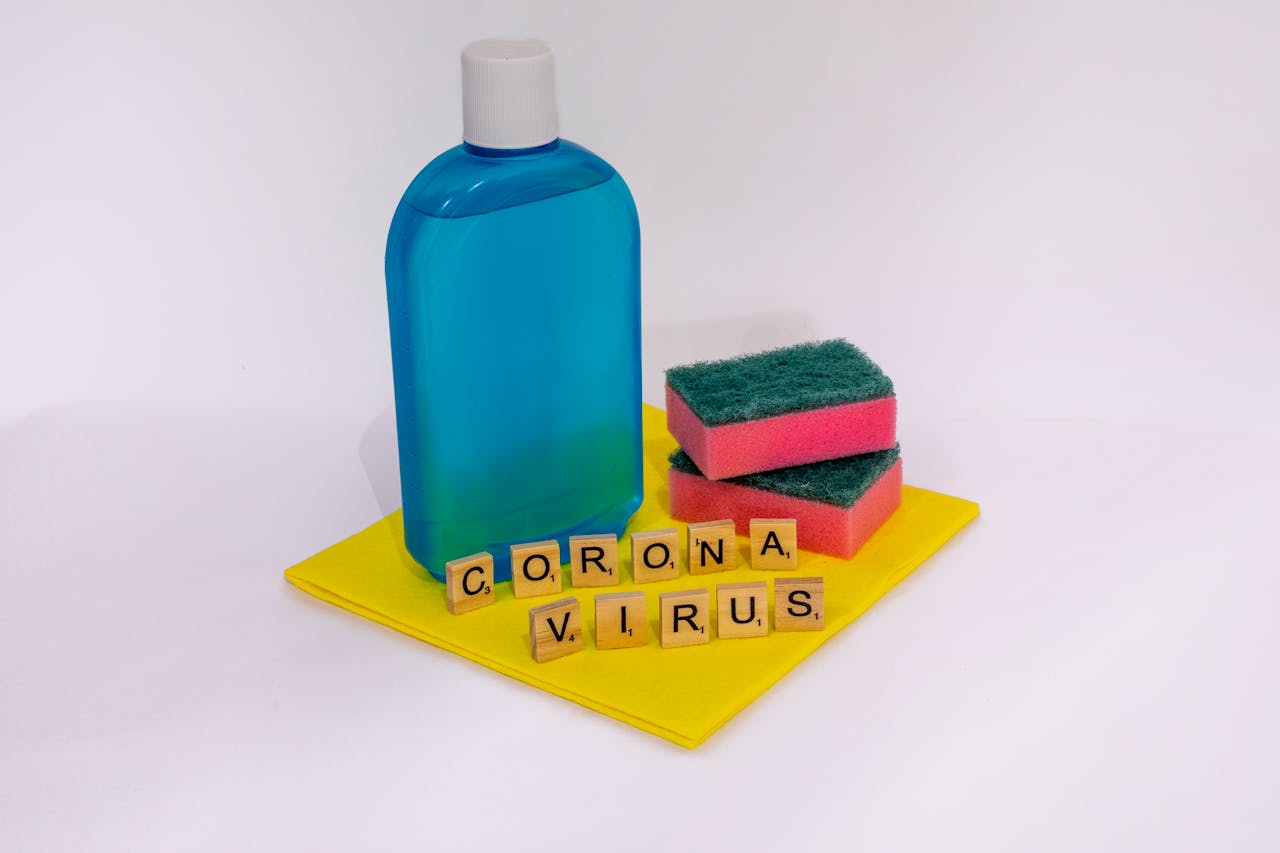 why-choose-us Cleaning products with scrabble tiles spelling coronavirus on a white surface.